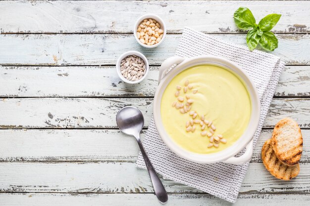 Zuppa di crema di cavolfiore bianco vegetariano in una ciotola bianca, vista dall'alto