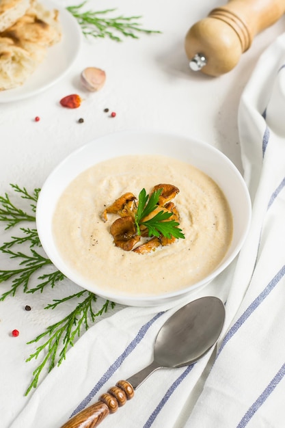 Zuppa di crema di finferli di funghi su sfondo bianco