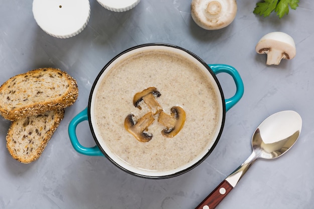 Zuppa di crema di funghi champignon con pane tostato sul tavolo di cemento grigio Vista dall'alto