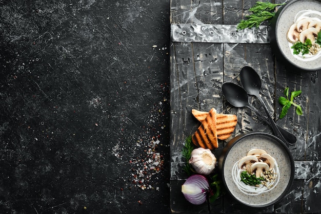 Zuppa di crema di funghi in una ciotola nera Menu vegetariano Vista dall'alto Spazio libero per il testo Stile rustico