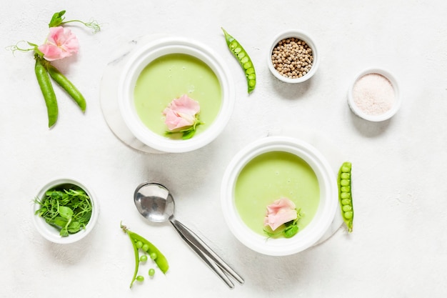 Zuppa di crema di piselli fresca fatta in casa con germogli di piselli e fiori