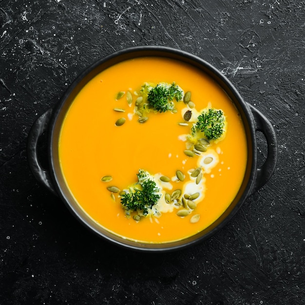 Zuppa di crema di zucca con semi di zucca in una lastra di pietra nera Menu autunnale Dieta Vista dall'alto Spazio libero per il testo