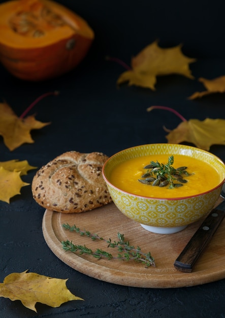 Zuppa di crema di zucca fatta in casa con formaggio, servita con semi e panino fresco.