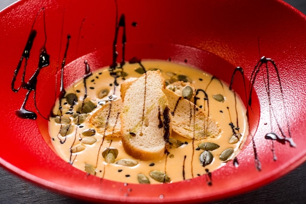Zuppa di crema di zucca saporita in grande piatto rosso