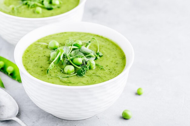 Zuppa di crema estiva con germogli di pisello fresco verde primo piano