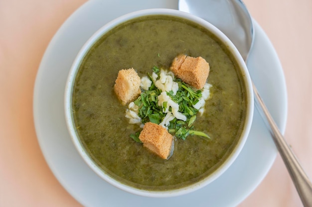 Zuppa di crema verde di spinaci con crostini di formaggio e prezzemolo fresco