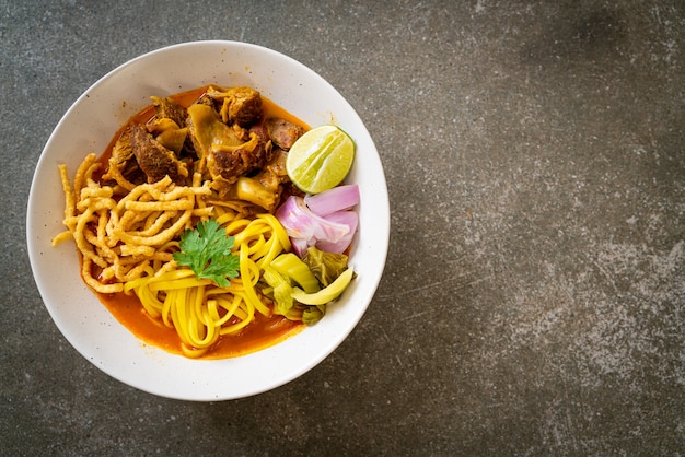 Zuppa di curry di pasta tailandese settentrionale con maiale brasato