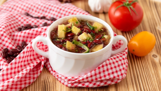 Zuppa di fagioli con carne in una ciotola di ceramica bianca.