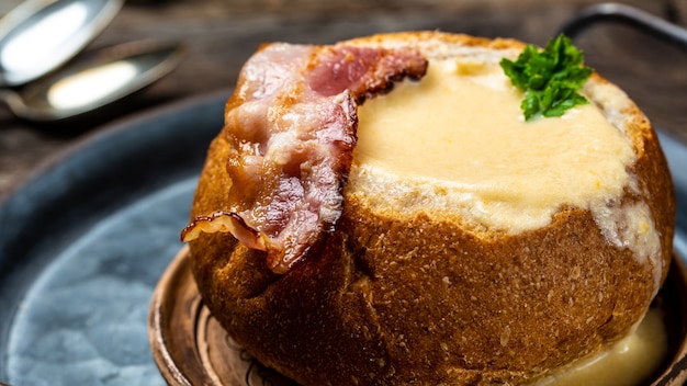 Zuppa di formaggio con pancetta ed erbe aromatiche servita nel pane