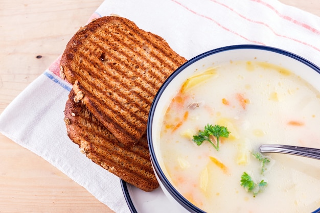 Zuppa di formaggio in un piatto bianco con pane tostato