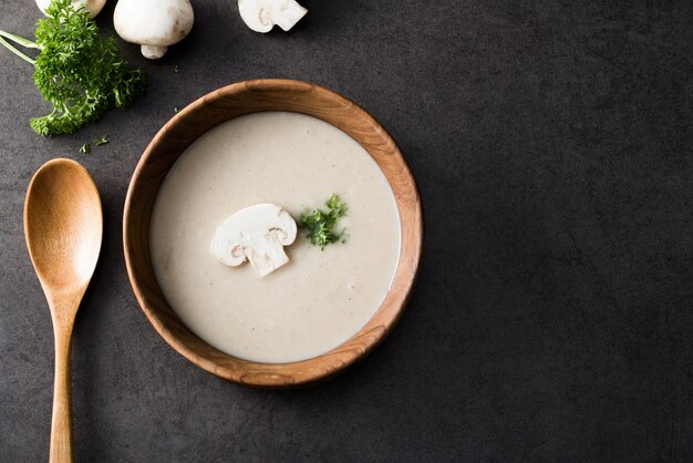 Zuppa di funghi cremosa su legno con funghi champignons