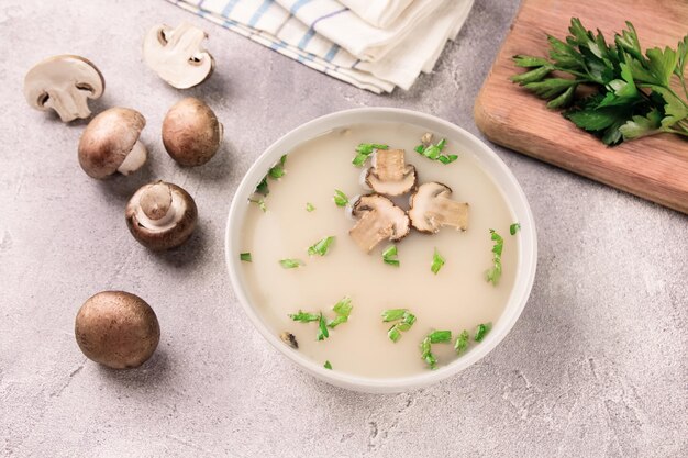 Zuppa di funghi fatta in casa in una ciotola su uno sfondo grigio Cibo delizioso