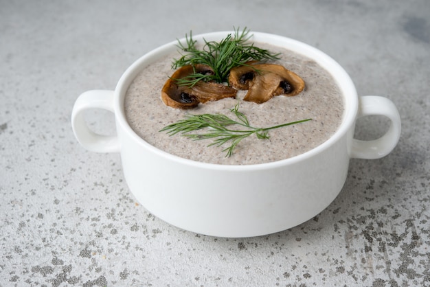 Zuppa di funghi prataioli crema in un piatto bianco