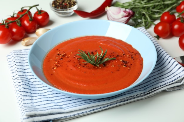 Zuppa di gazpacho e ingredienti su sfondo bianco