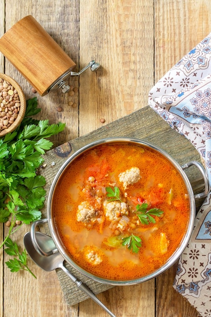 Zuppa di lenticchie al pomodoro con polpette e verdure su un tavolo di legno Vista dall'alto Copia spazio