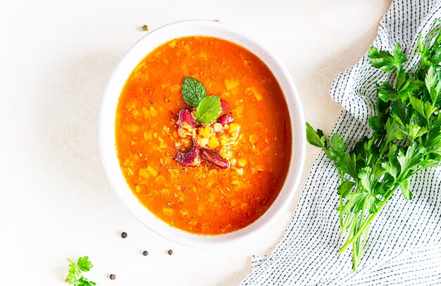 Zuppa di lenticchie e fagioli rossi fatta in casa con contorno di verdure e erbe aromatiche.