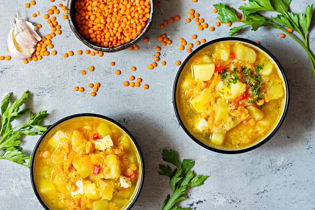 Zuppa di lenticchie rosse e verdure in una ciotola su sfondo blu.Piatto tradizionale turco