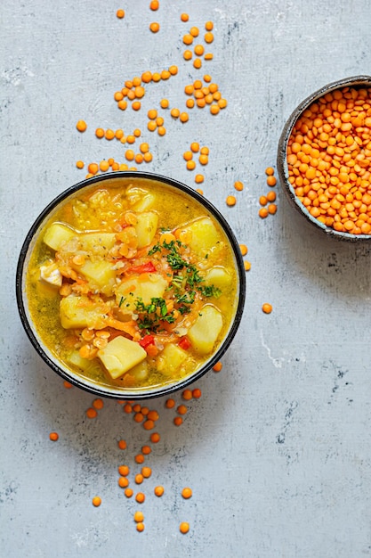 Zuppa di lenticchie rosse e verdure in una ciotola su sfondo blu.Piatto tradizionale turco