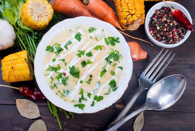 Zuppa di mais in un piatto di ceramica e ingredienti