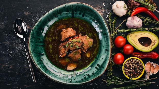 Zuppa di manzo e verdure Vista dall'alto su sfondo di legno nero Copia spazio