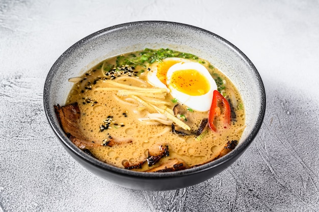 Zuppa di noodle asiatici Ramen con carne di lingua di manzo, funghi e uovo in salamoia Ajitama. Sfondo bianco. Vista dall'alto