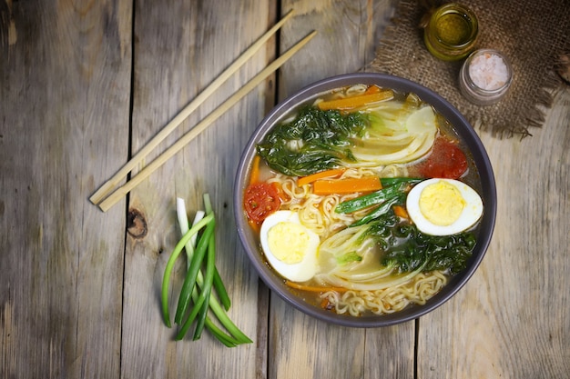 Zuppa di noodle con uovo e cavolo cinese in una ciotola.