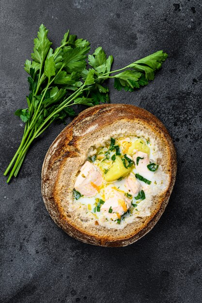 Zuppa di pesce cremosa finlandese con salmone, trota, patate servite nel pane.