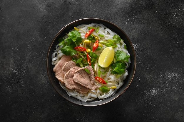 Zuppa di Pho bo con manzo in ciotola su sfondo nero cucina vietnamita