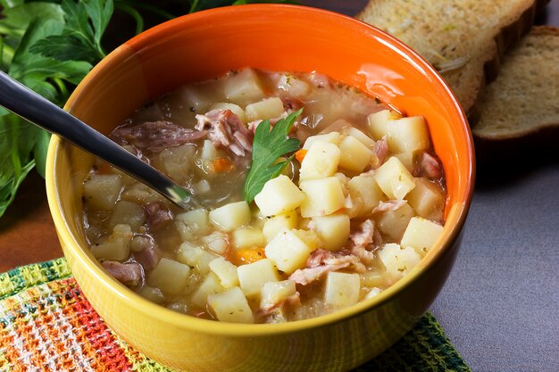 Zuppa di piselli con prezzemolo in una ciotola con crostini con aglio