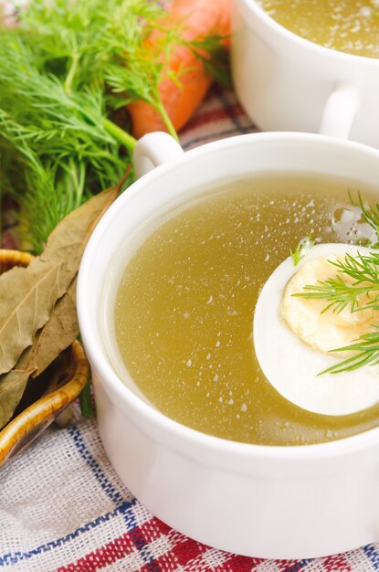 Zuppa di pollo con uovo e aneto in una tazza