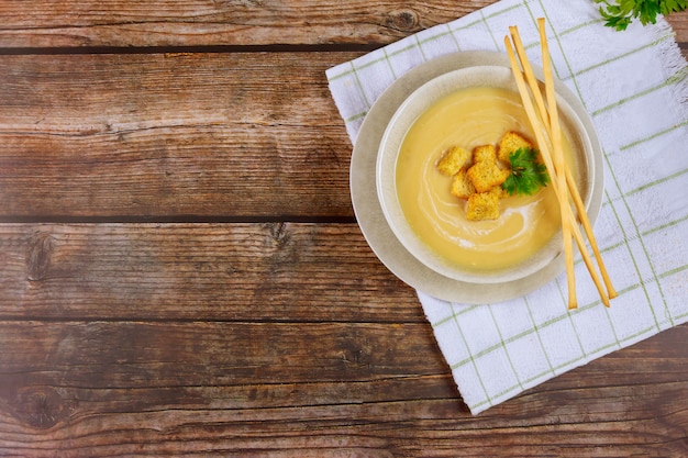 Zuppa di pollo cremosa fatta in casa in una ciotola grigia guarnita con crostini di pane croccante.