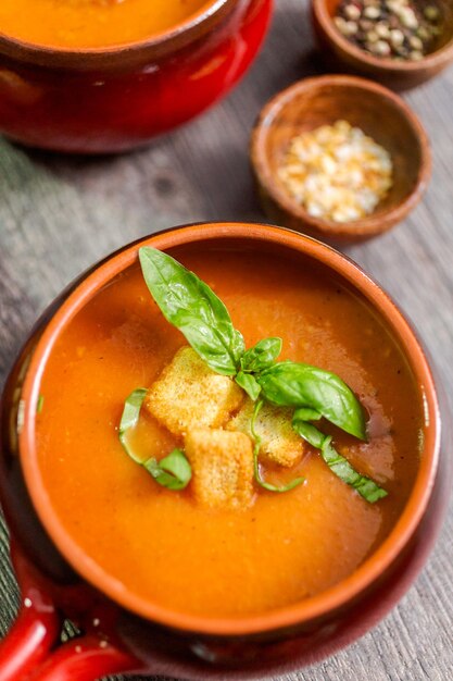 Zuppa di pomodoro arrosto con basilico fresco e crostini di pane.