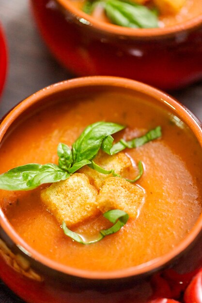 Zuppa di pomodoro arrosto con basilico fresco e crostini di pane.