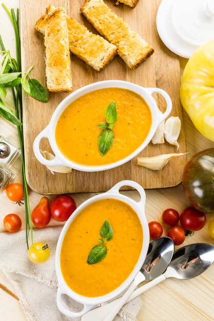 Zuppa di pomodoro arrosto cucinata con pomodori cimelio biologici e servita con sandwich al formaggio grigliato.