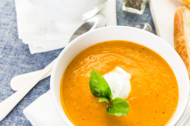 Zuppa di pomodoro arrosto cucinata con pomodori cimelio biologici e servita con sandwich al formaggio grigliato.