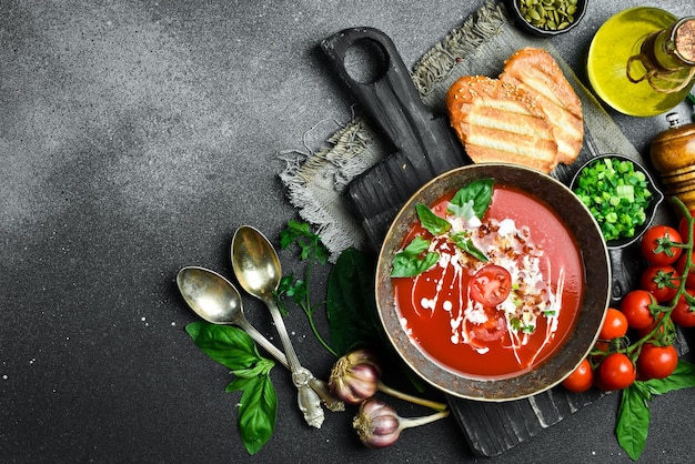 Zuppa di pomodoro con basilico e panna in una ciotola Concetto di cibo sano Primo piano