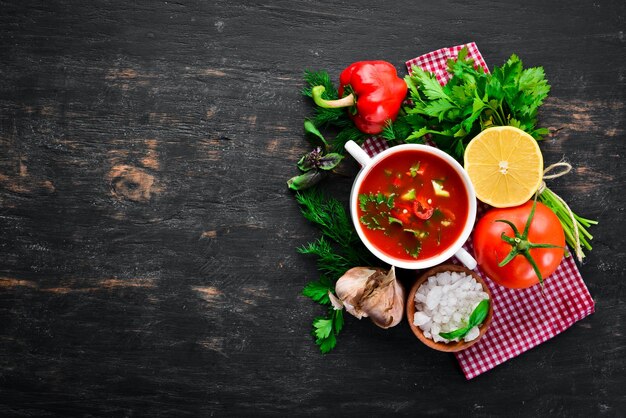 Zuppa di pomodoro con cipolla, cetriolo e paprika Vista dall'alto su sfondo nero Spazio libero per il testo