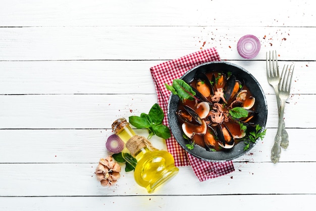 Zuppa di pomodoro con frutti di mare Cozze vongole e polpi Sullo sfondo vecchio Vista dall'alto Spazio libero per la copia