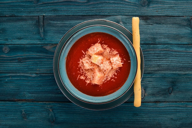 Zuppa di pomodoro con parmigiano su fondo di legno Vista dall'alto Spazio di copia