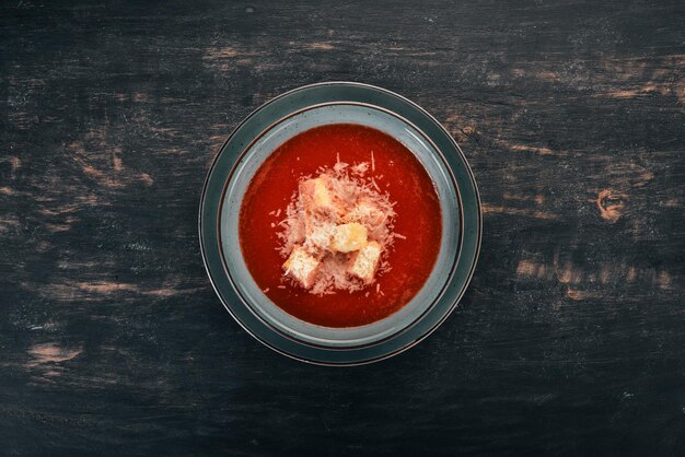 Zuppa di pomodoro con parmigiano su fondo di legno Vista dall'alto Spazio di copia