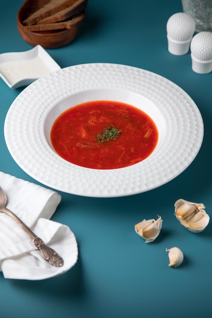 Zuppa di pomodoro e carne su sfondo blu Polpette di fagioli di pomodoro piccante sul cucchiaio di legno