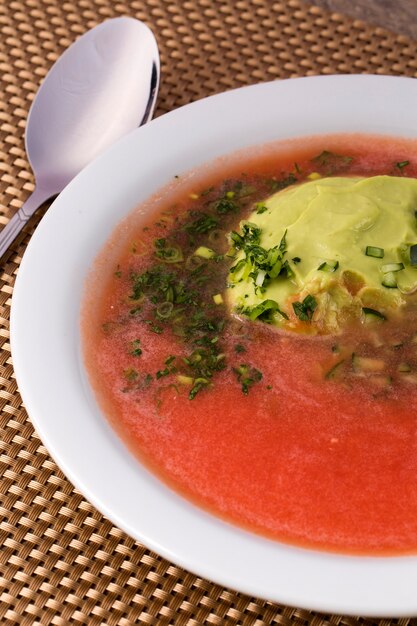 zuppa di pomodoro fresco in una ciotola bianca con avocado