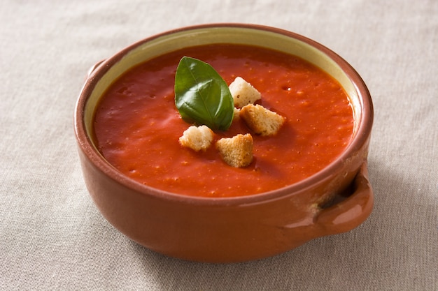 Zuppa di pomodoro in ciotola marrone guarnita con crostini