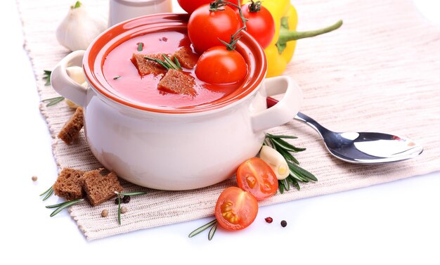 Zuppa di pomodoro saporita e verdure isolate su bianco