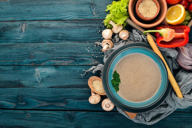 Zuppa di purè di funghi Cibo sano Vista dall'alto Su uno sfondo di legno blu Copia spazio