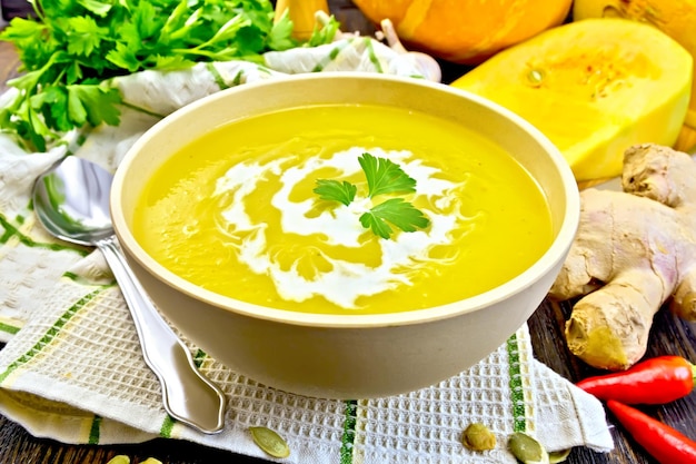 Zuppa di purea di zucca con crema in una ciotola sul tovagliolo