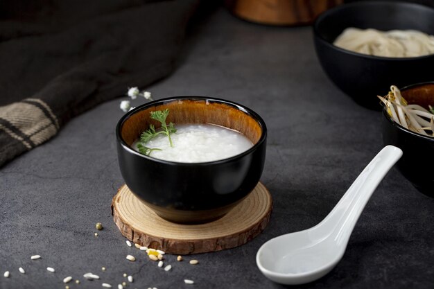 zuppa di riso ciotola nera supporto di legno cucchiaio bianco alta qualità e risoluzione bellissimo concetto fotografico