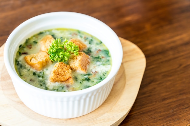 zuppa di spinaci con pane in una ciotola bianca