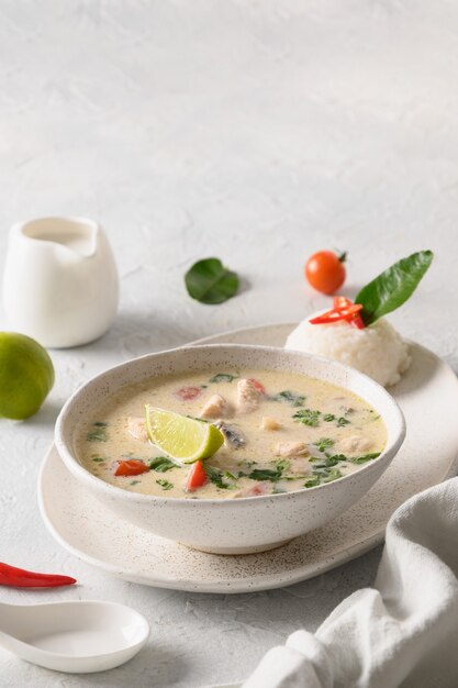 Zuppa di tom kha gai piccante al cocco con cibo tailandese asiatico di pollo pomodorini