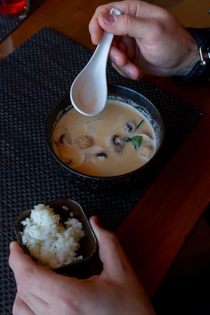 zuppa di tom yam in un piatto fondo di ceramica, cibo liquido in un ristorante, zuppa giapponese con tom yam ai frutti di mare